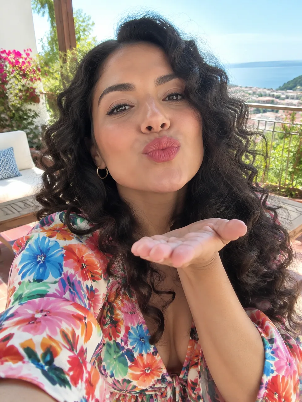 Original photo: woman with curly hair blowing a kiss on a terrace