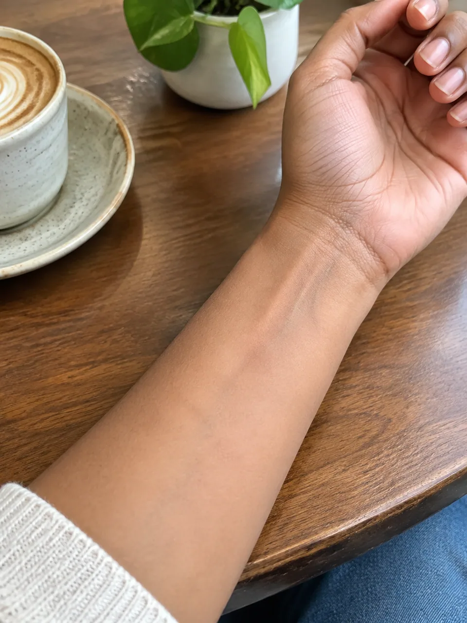 Original photo: bare inner wrist resting on a café table