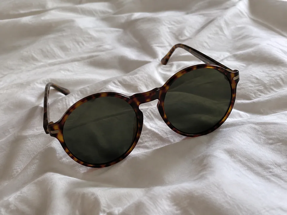 Original photo: tortoiseshell sunglasses on a bed sheet
