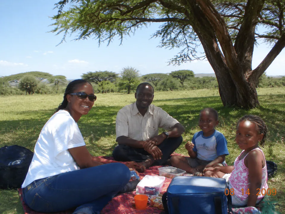 Family picnic photo under an acacia with an orange camera date stamp
